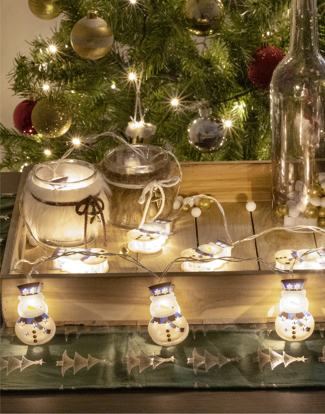 liggende led sneeuwpoppen in een houten plankje bij de kerstboom